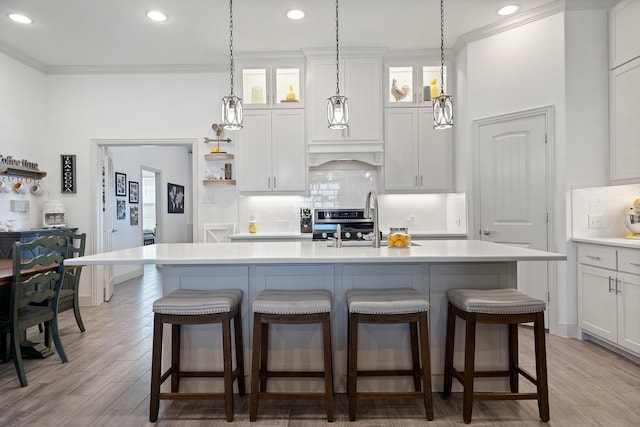 kitchen featuring range, ornamental molding, light countertops, and custom range hood