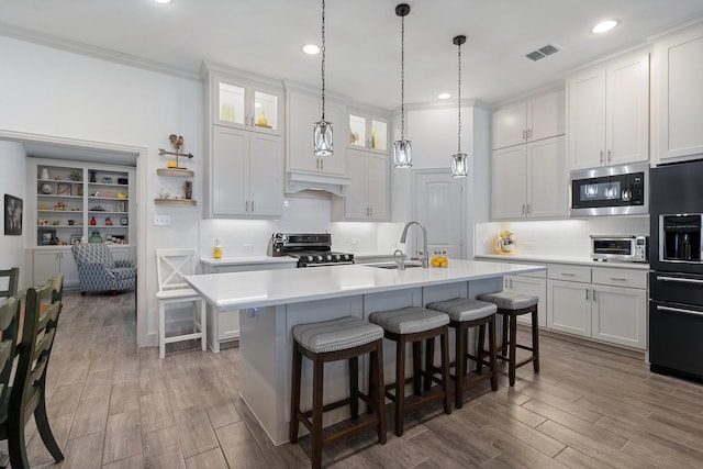 kitchen featuring a breakfast bar, visible vents, stainless steel appliances, and light countertops