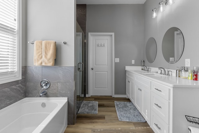 bathroom with hardwood / wood-style flooring, vanity, and a bathtub