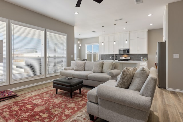 living room featuring ceiling fan and light hardwood / wood-style flooring