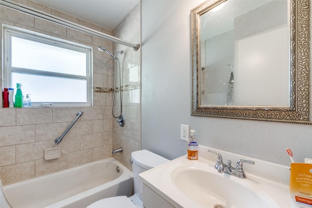 full bathroom with vanity, tiled shower / bath combo, and toilet