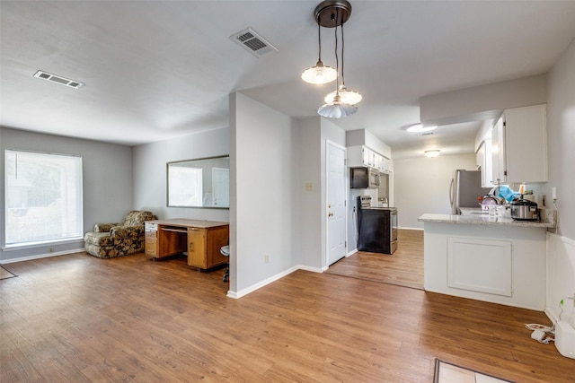 kitchen with appliances with stainless steel finishes, white cabinets, light wood-type flooring, and kitchen peninsula