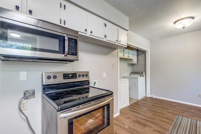 kitchen with washing machine and dryer, appliances with stainless steel finishes, white cabinets, and light hardwood / wood-style flooring