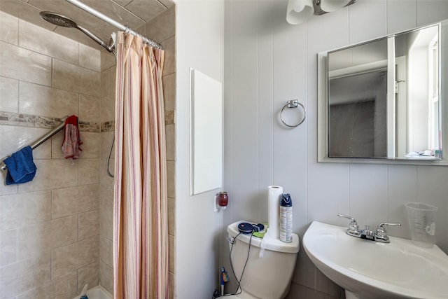 bathroom featuring sink, curtained shower, and toilet