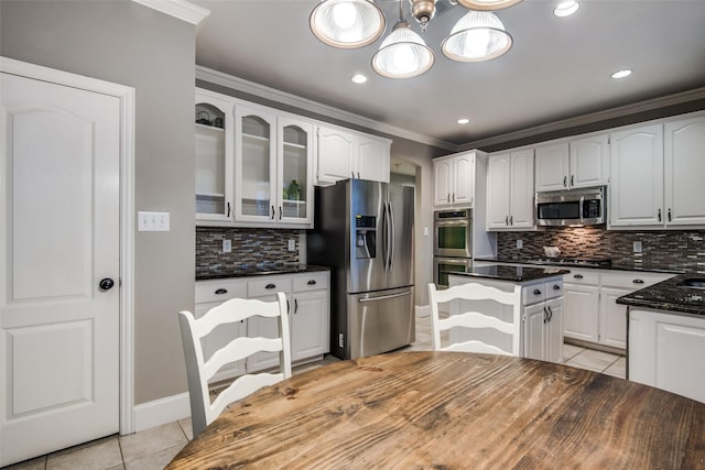 kitchen featuring white cabinetry, a center island, light tile patterned floors, stainless steel appliances, and crown molding