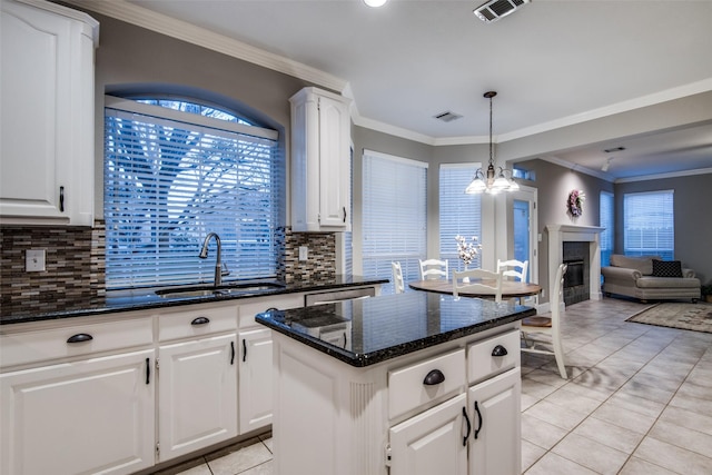 kitchen with white cabinetry, a center island, and sink