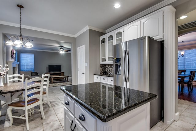 kitchen with crown molding, a center island, hanging light fixtures, stainless steel fridge, and white cabinets