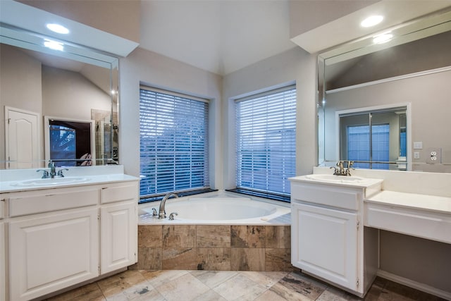 bathroom with a relaxing tiled tub and vanity