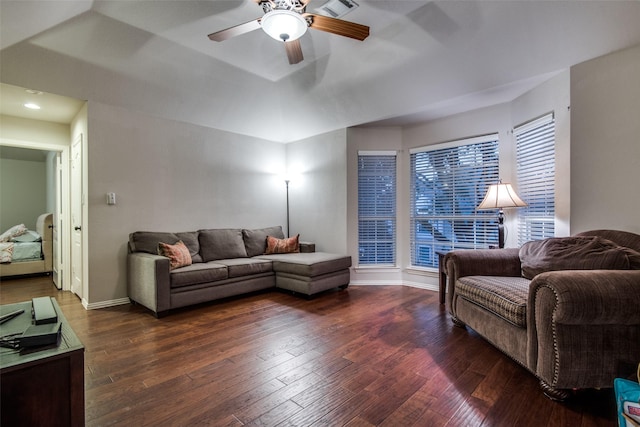 living room featuring ceiling fan, a tray ceiling, and dark hardwood / wood-style flooring