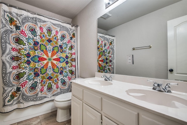 full bathroom with vanity, shower / bath combo, and toilet