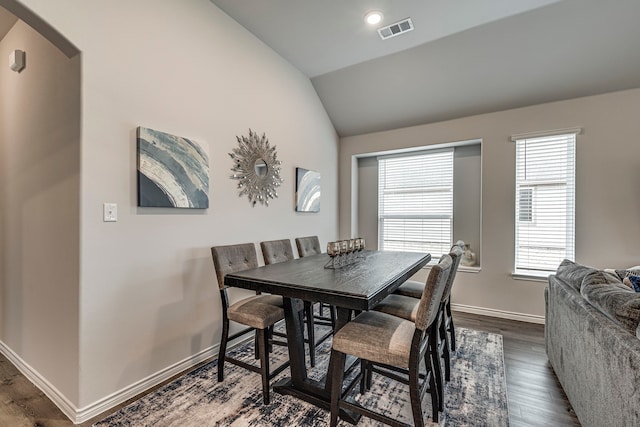 dining space featuring lofted ceiling and dark hardwood / wood-style flooring