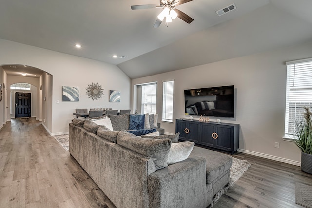 living room with ceiling fan, lofted ceiling, and light hardwood / wood-style floors