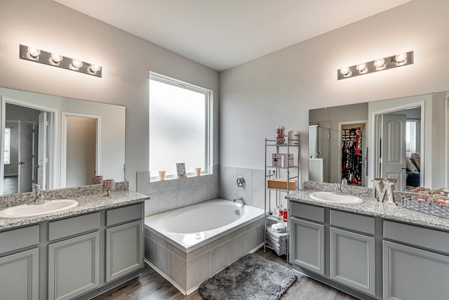 bathroom featuring vanity, separate shower and tub, and hardwood / wood-style floors