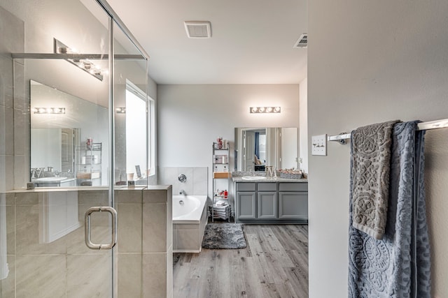 bathroom featuring vanity, hardwood / wood-style floors, and separate shower and tub