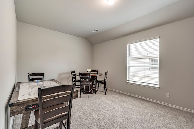 carpeted dining area featuring lofted ceiling