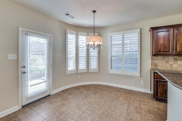 unfurnished dining area with light tile patterned flooring and a chandelier