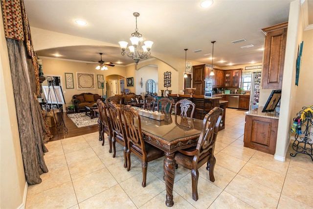 dining area featuring crown molding, ceiling fan with notable chandelier, and light tile patterned floors