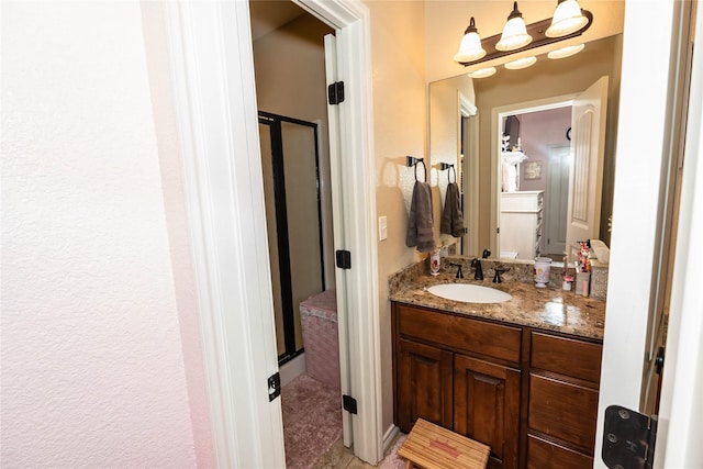 bathroom with vanity and a shower with door