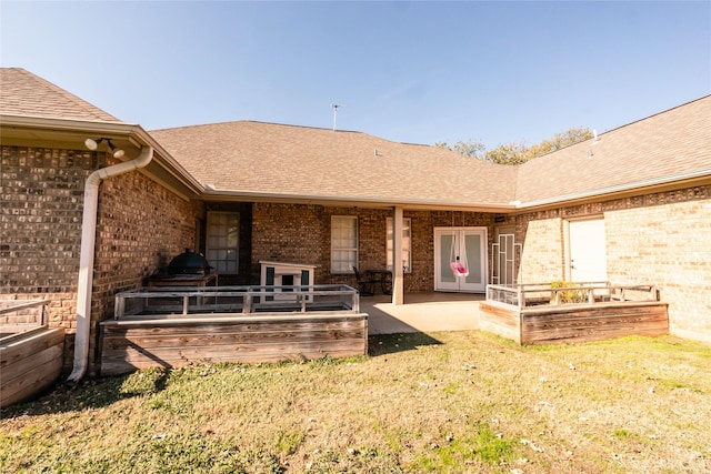 back of house featuring a patio area, french doors, and a lawn