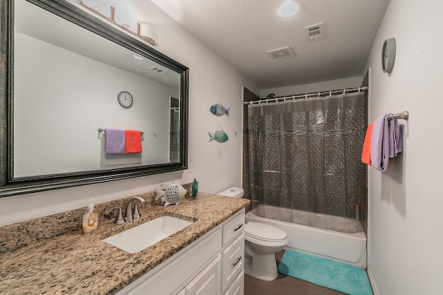 full bathroom featuring vanity, shower / bath combo, a textured ceiling, and toilet