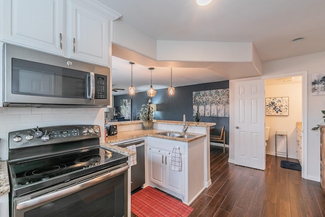 kitchen featuring pendant lighting, sink, white cabinets, kitchen peninsula, and stainless steel appliances