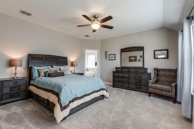 bedroom featuring lofted ceiling, light carpet, connected bathroom, and ceiling fan