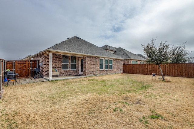 rear view of house featuring a patio and a yard