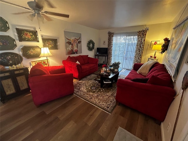 living room featuring dark wood-type flooring and ceiling fan