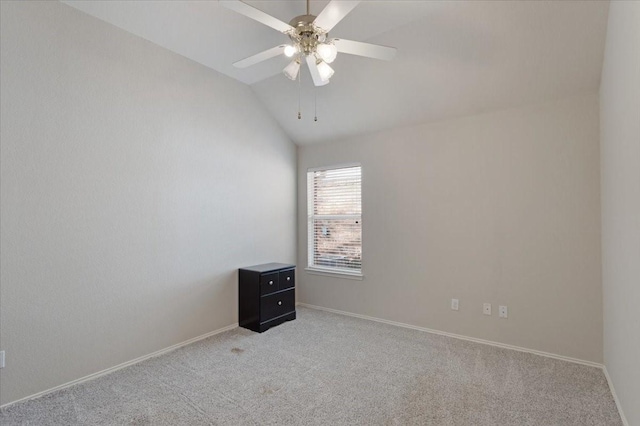 carpeted spare room featuring vaulted ceiling and ceiling fan