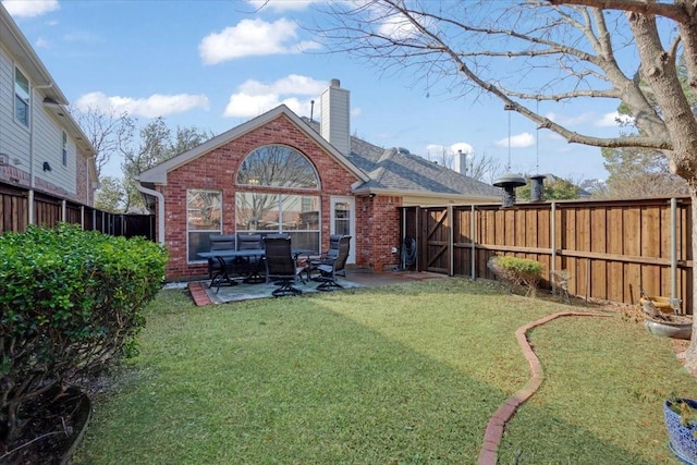 back of property with a yard and a patio