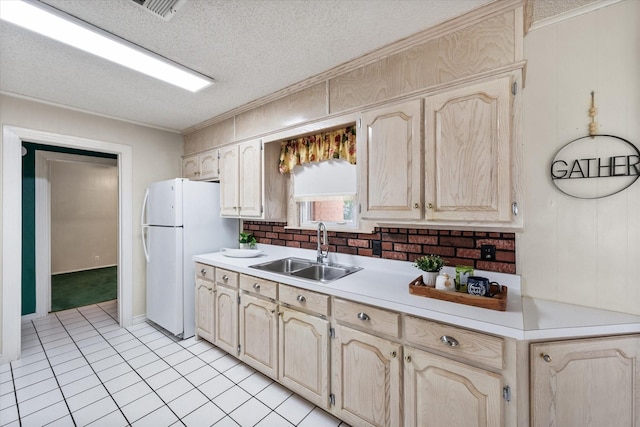 kitchen featuring sink, ornamental molding, a textured ceiling, and white refrigerator