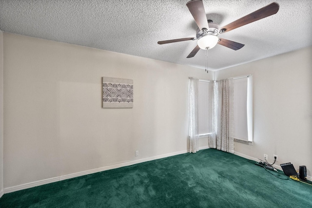 empty room featuring ceiling fan, dark carpet, and a textured ceiling