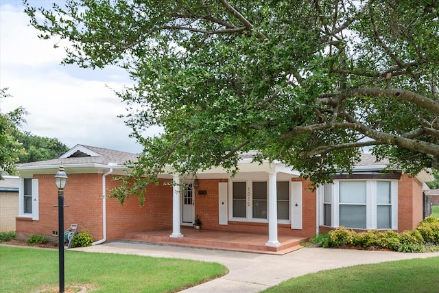 view of front of property featuring covered porch and a front lawn