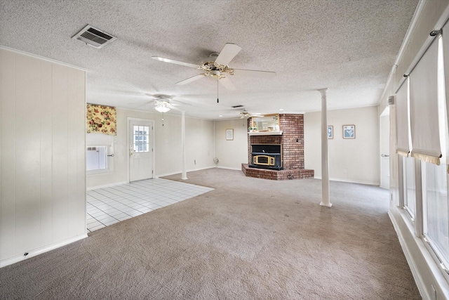 unfurnished living room with a brick fireplace, light colored carpet, a textured ceiling, and ceiling fan