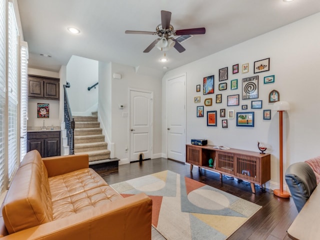 living room with dark wood-type flooring, ceiling fan, and sink