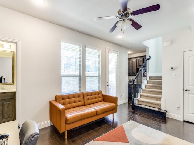 living room featuring dark wood-type flooring and ceiling fan