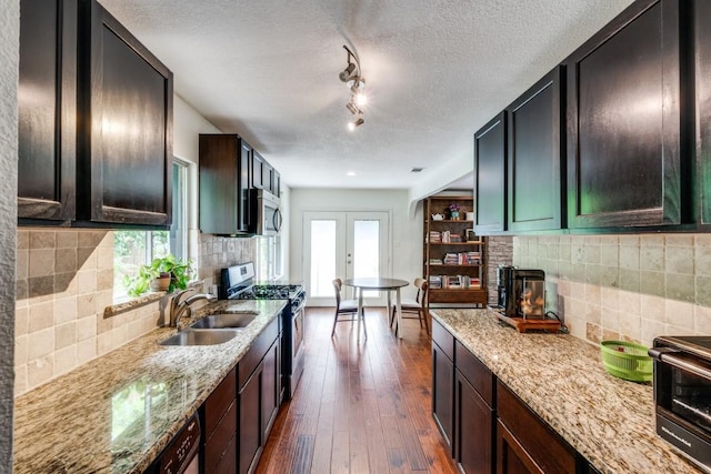 kitchen with stainless steel appliances, sink, a fireplace, and french doors