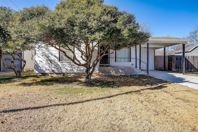 view of front facade featuring a carport, covered porch, and a front lawn