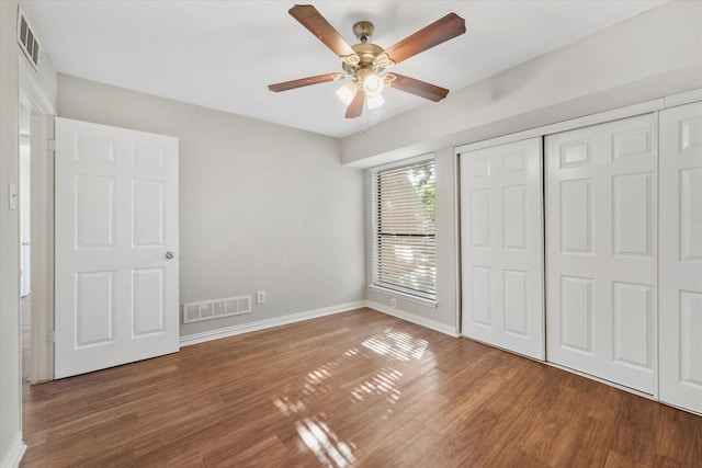 unfurnished bedroom featuring ceiling fan, wood-type flooring, and a closet