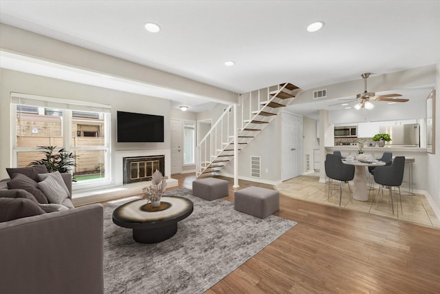 living room featuring ceiling fan and light hardwood / wood-style floors