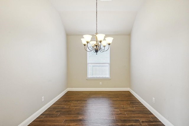 unfurnished room featuring lofted ceiling, dark hardwood / wood-style flooring, and a notable chandelier