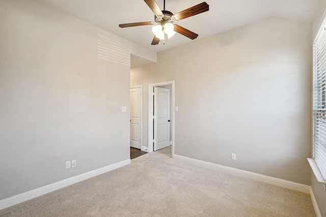 spare room featuring lofted ceiling, carpet floors, and ceiling fan