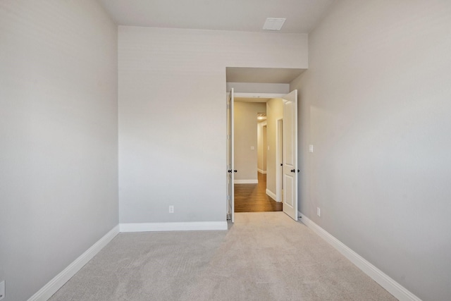 unfurnished room featuring light colored carpet