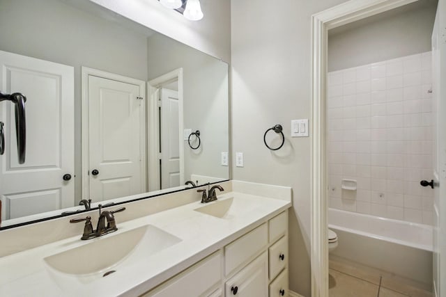 full bathroom featuring vanity, toilet, tiled shower / bath combo, and tile patterned flooring