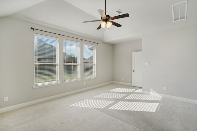 spare room featuring lofted ceiling, light colored carpet, and ceiling fan