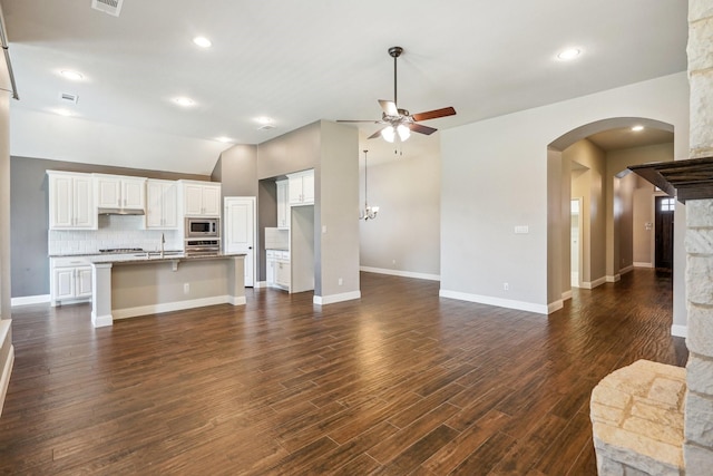 unfurnished living room with sink, dark hardwood / wood-style floors, and ceiling fan with notable chandelier