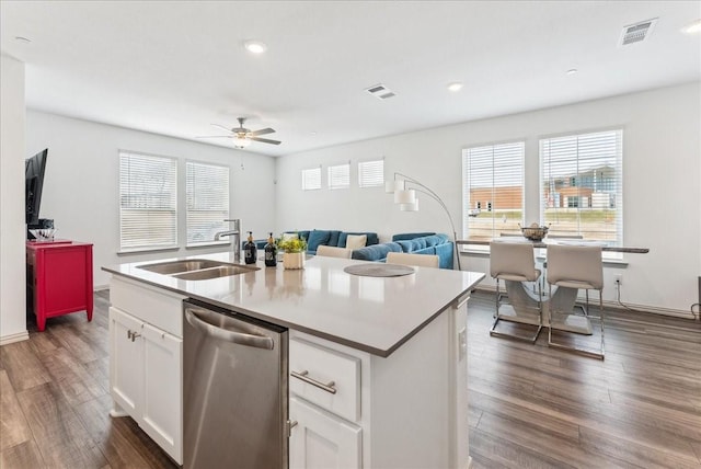 kitchen featuring dark wood-type flooring, visible vents, dishwasher, and a sink