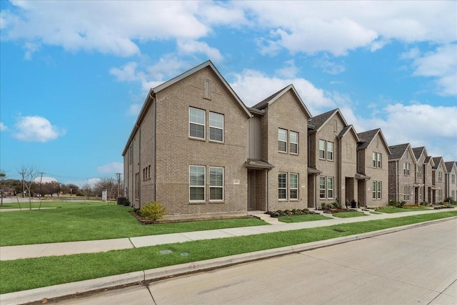 traditional home featuring a residential view, a front lawn, and brick siding