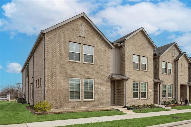 view of front of home with a front lawn and brick siding