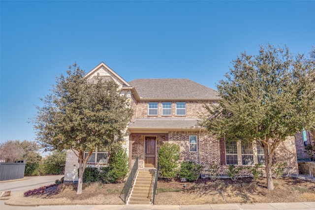 traditional home with brick siding and roof with shingles